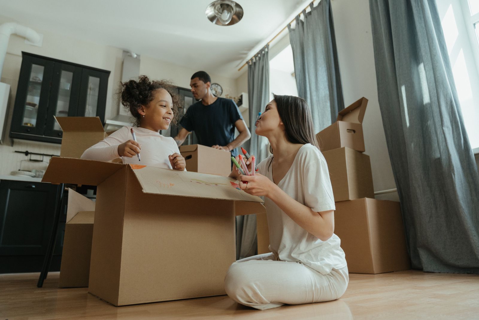 Eine Familie packt Umzugskartons im neuen Zuhause aus